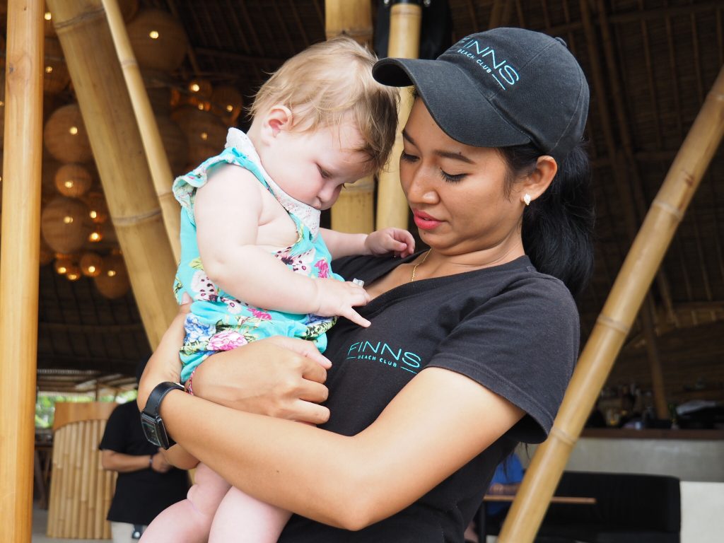 , bali with our daughter .A friendly local waitress helping us at Finns Beach Club, Bali